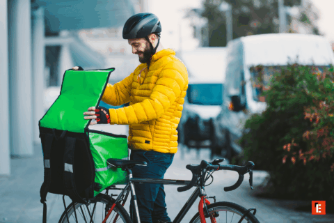 Delivery person preparing food on their bicycle.