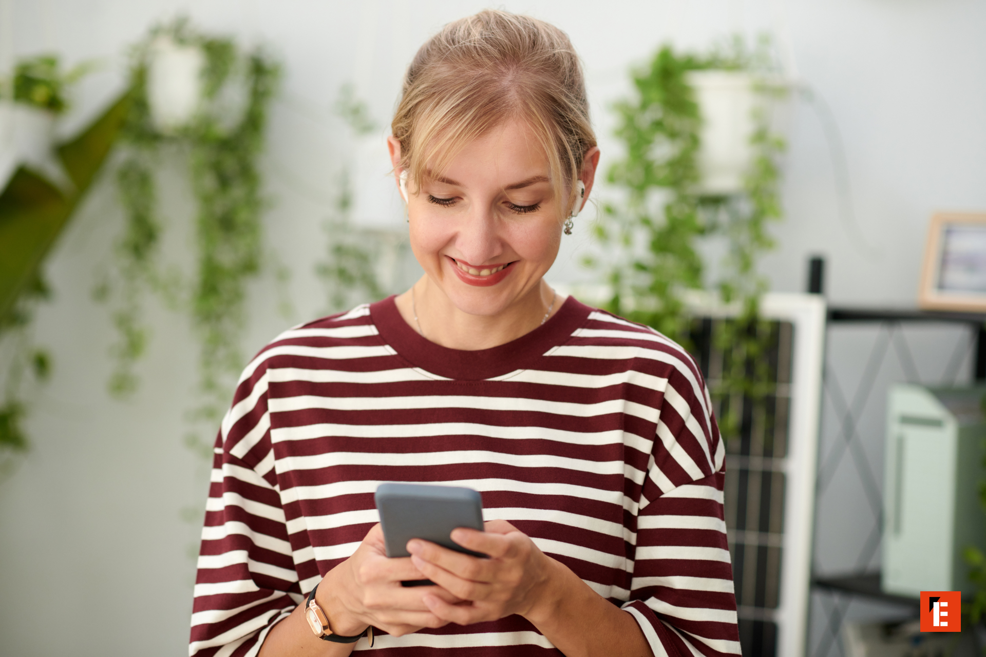 Smiling woman checking phone in a vibrant setting.