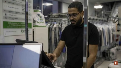 Homme travaillant devant un ordinateur dans un magasin.
