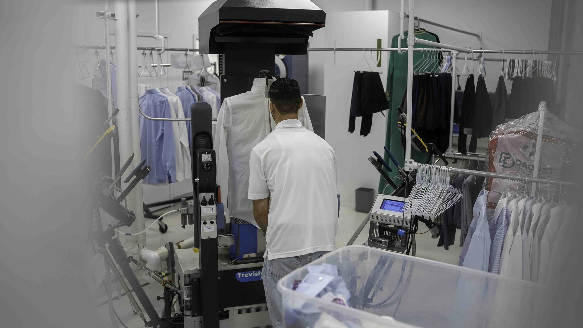 Un homme de dos entrain de repasser une chemise