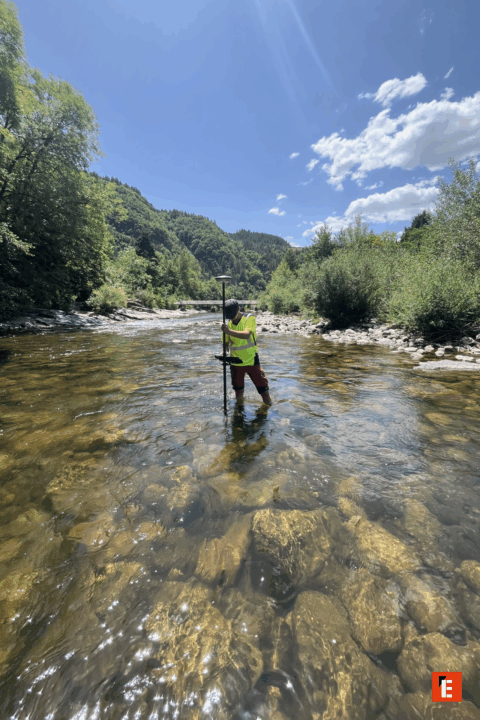Personne debout dans une rivière, mesurant l'eau.