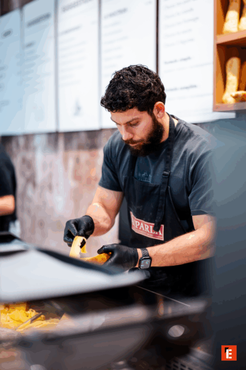 Homme préparant des plats dans un restaurant.