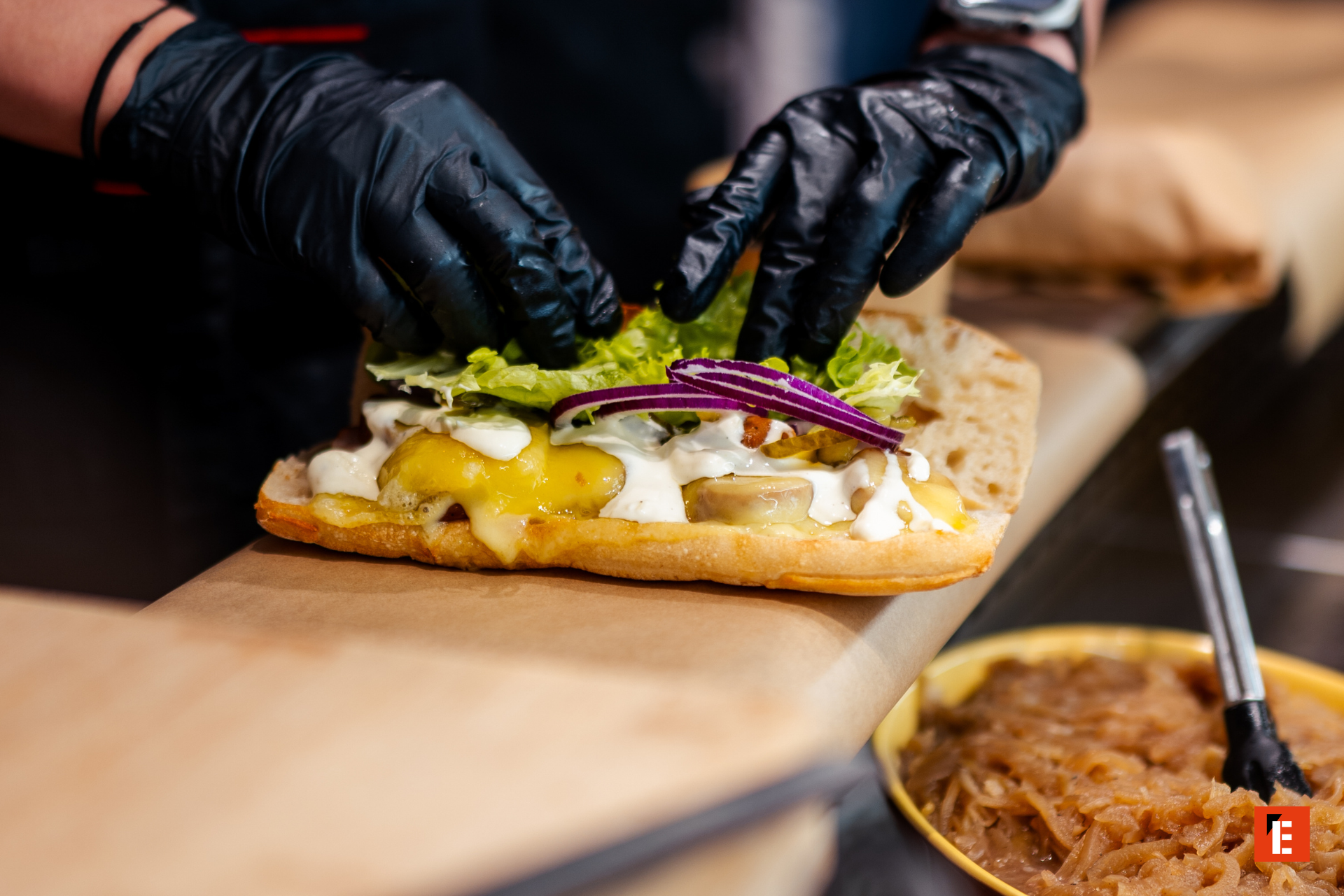 Préparation d'un sandwich avec garnitures fraîches.