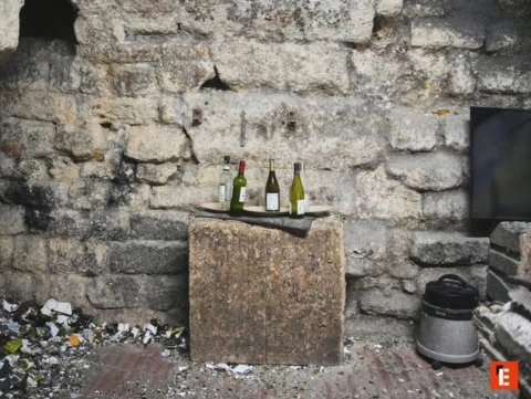 Quatre bouteilles sur une table en pierre.