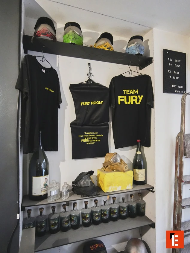 Vêtements et bouteilles sur une étagère.