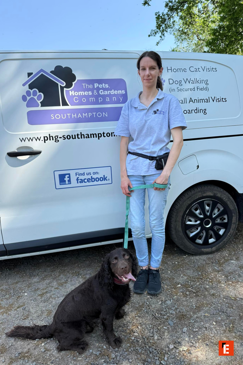 Woman with a dog by a pet services van.