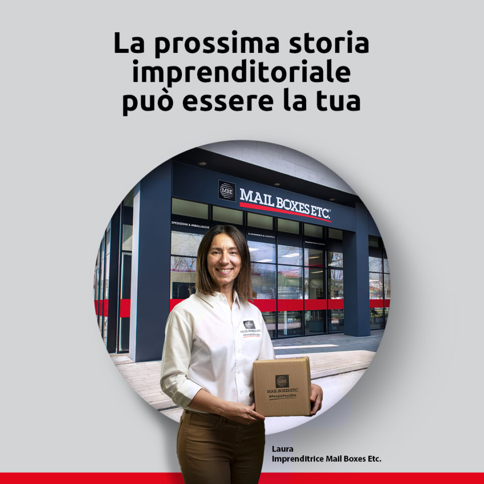 Imprenditrice con un pacco davanti al negozio.