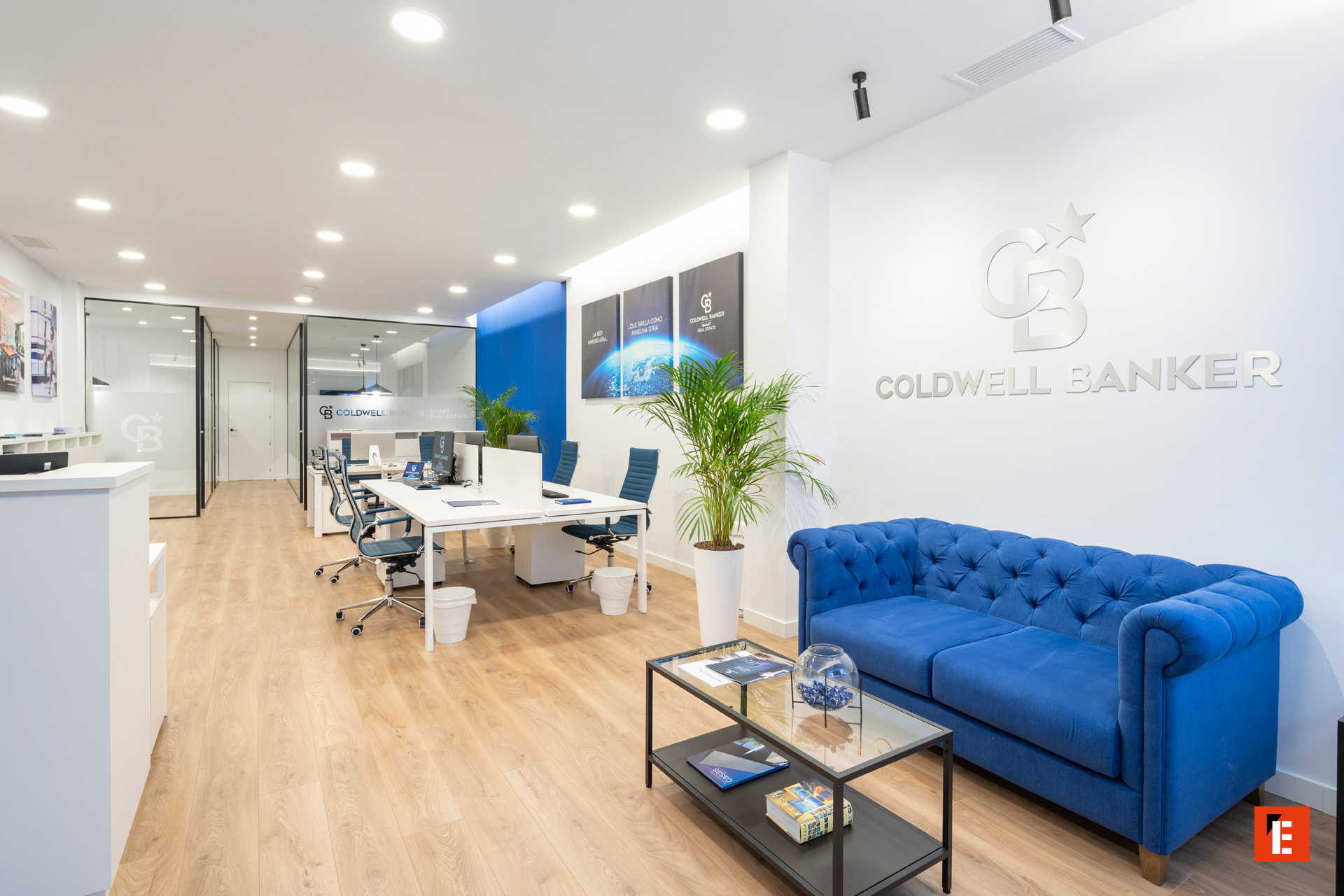 Oficina moderna de Coldwell Banker con mobiliario claro.