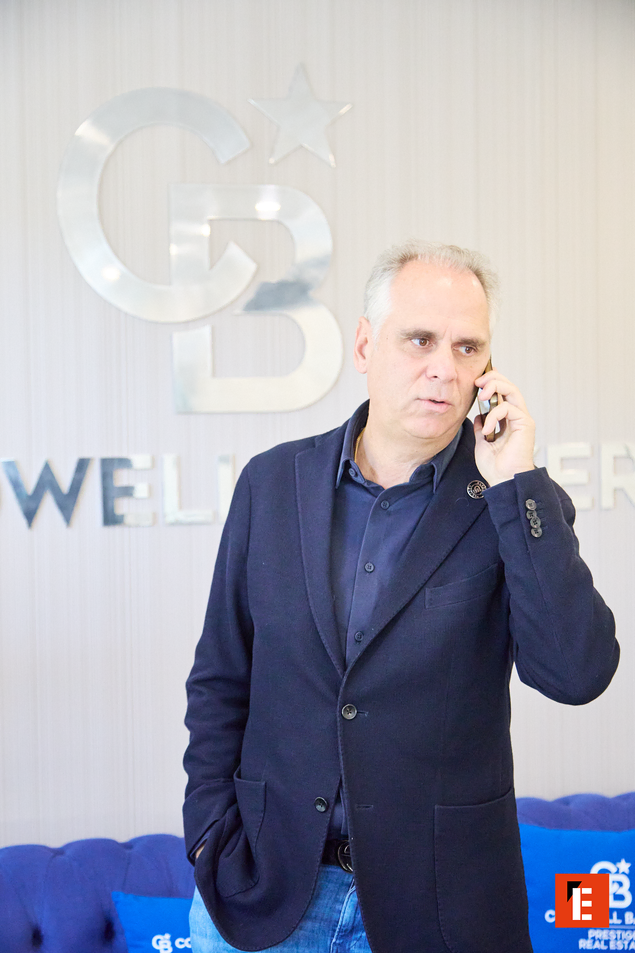 Sala de espera moderna con sofá azul y decoración.