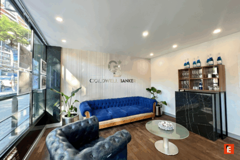 Sala de espera moderna con sofá azul y decoración.