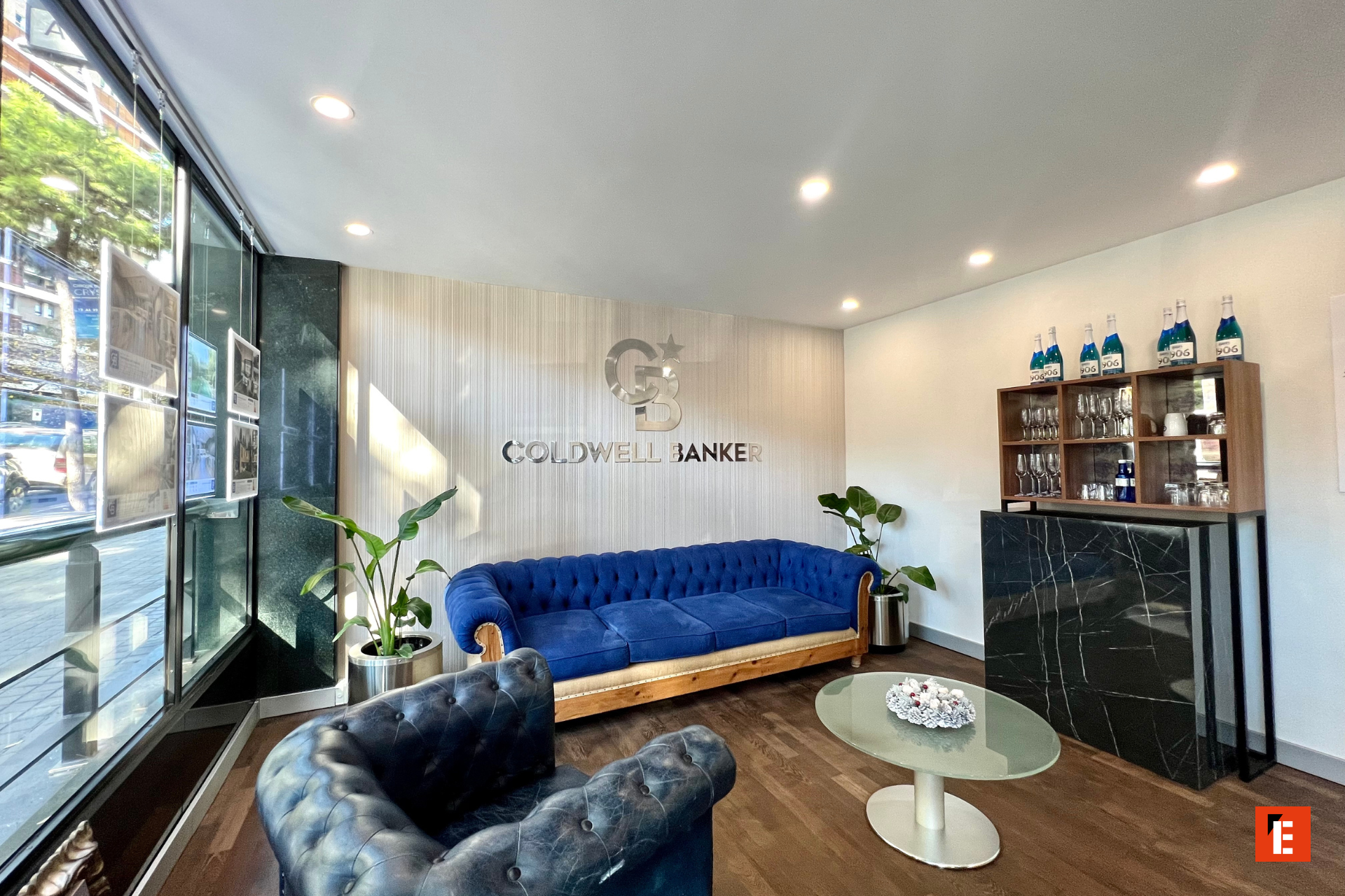 Sala de espera moderna con sofá azul y decoración.