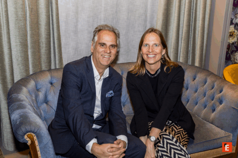 Pareja sonriente sentada en un sofá elegante.