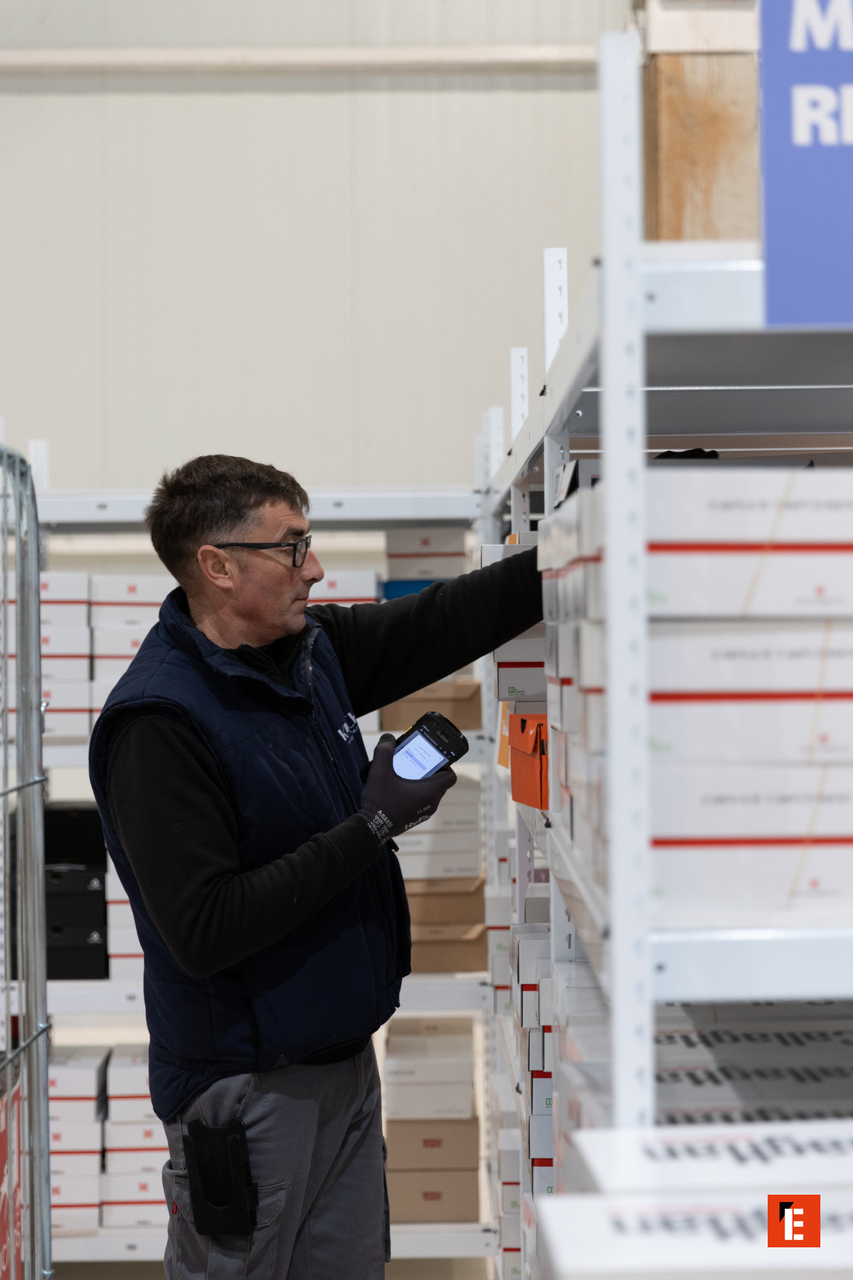 Hombre escaneando cajas en un almacén.
