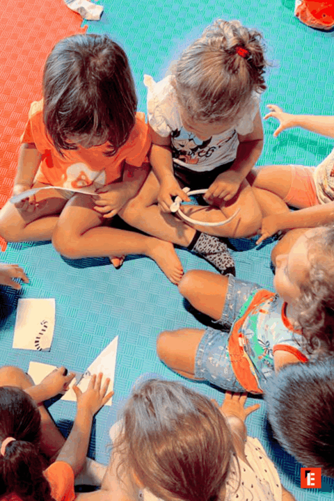 Niños colaborando en actividades creativas en grupo.