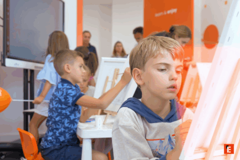 Niños pintando en un aula creativa.
