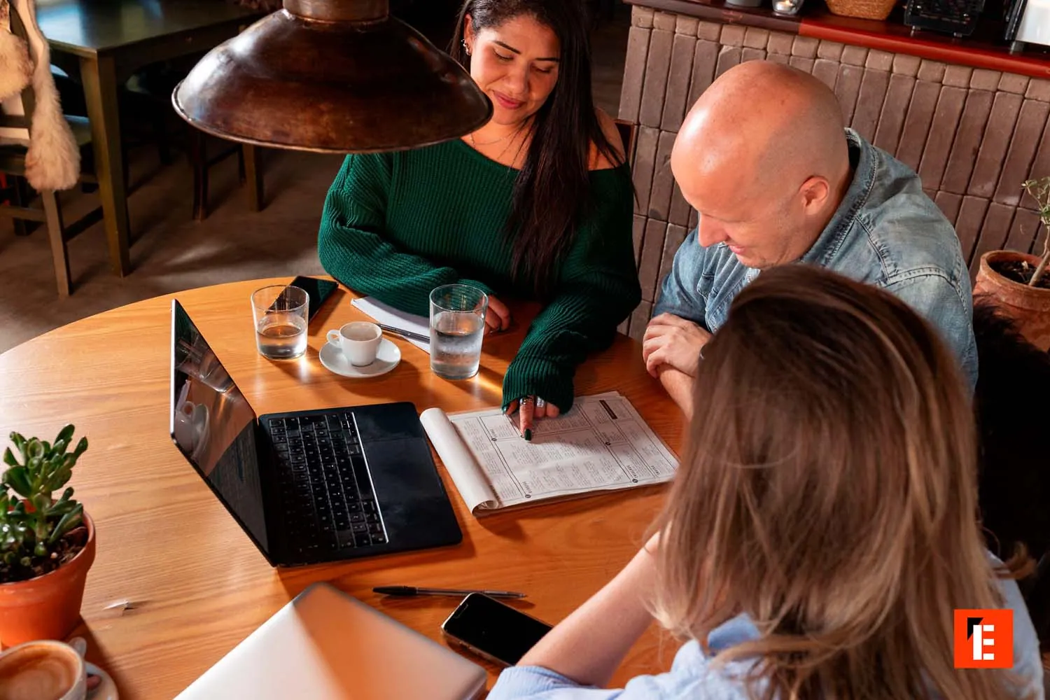 Grupo discutiendo en una mesa con computadora.