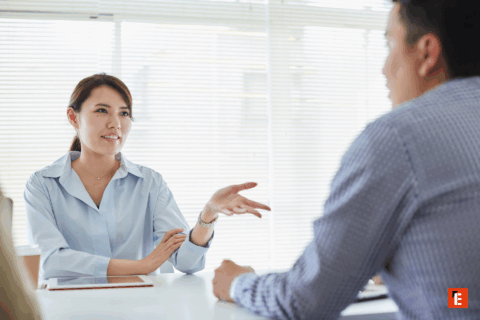 Discussion entre deux personnes dans un bureau.