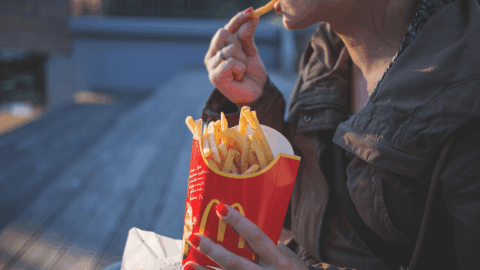 persona comiendo patatas fritas de mcdonald's