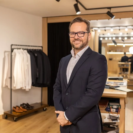 Hombre sonriente en una tienda de ropa elegante.