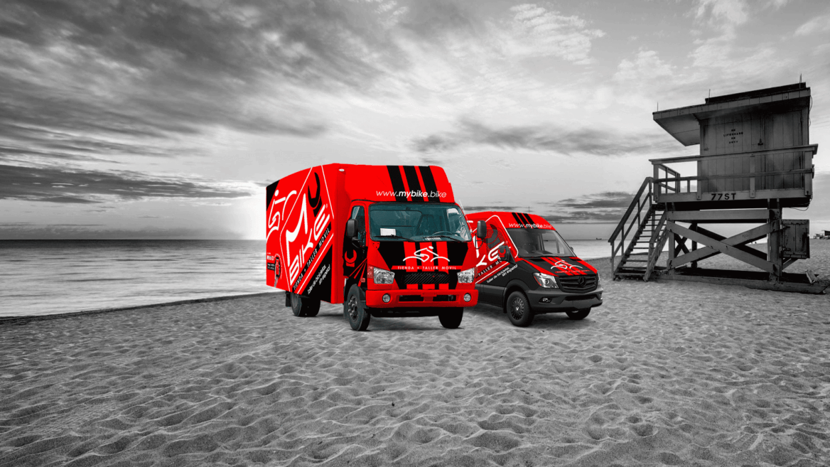 camión y furgoneta en una playa de mybike