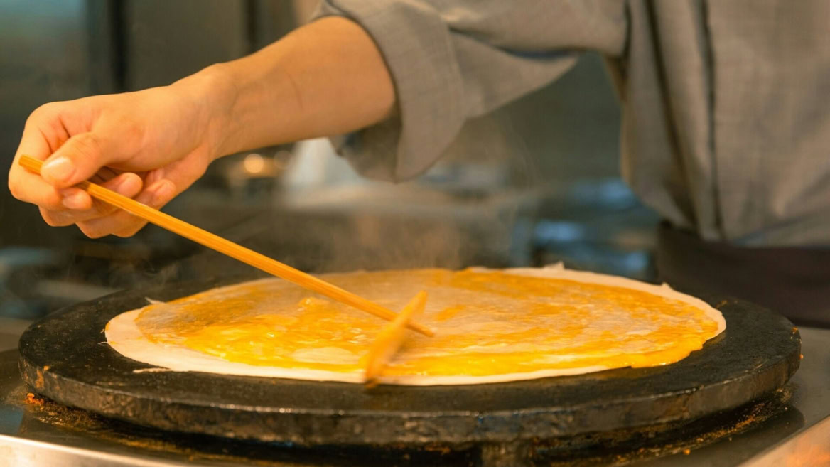 Personne en train de faire une crêpe