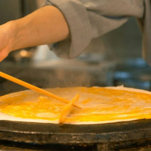 Personne en train de faire une crêpe