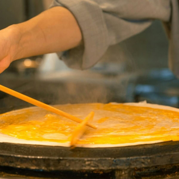 Personne en train de faire une crêpe