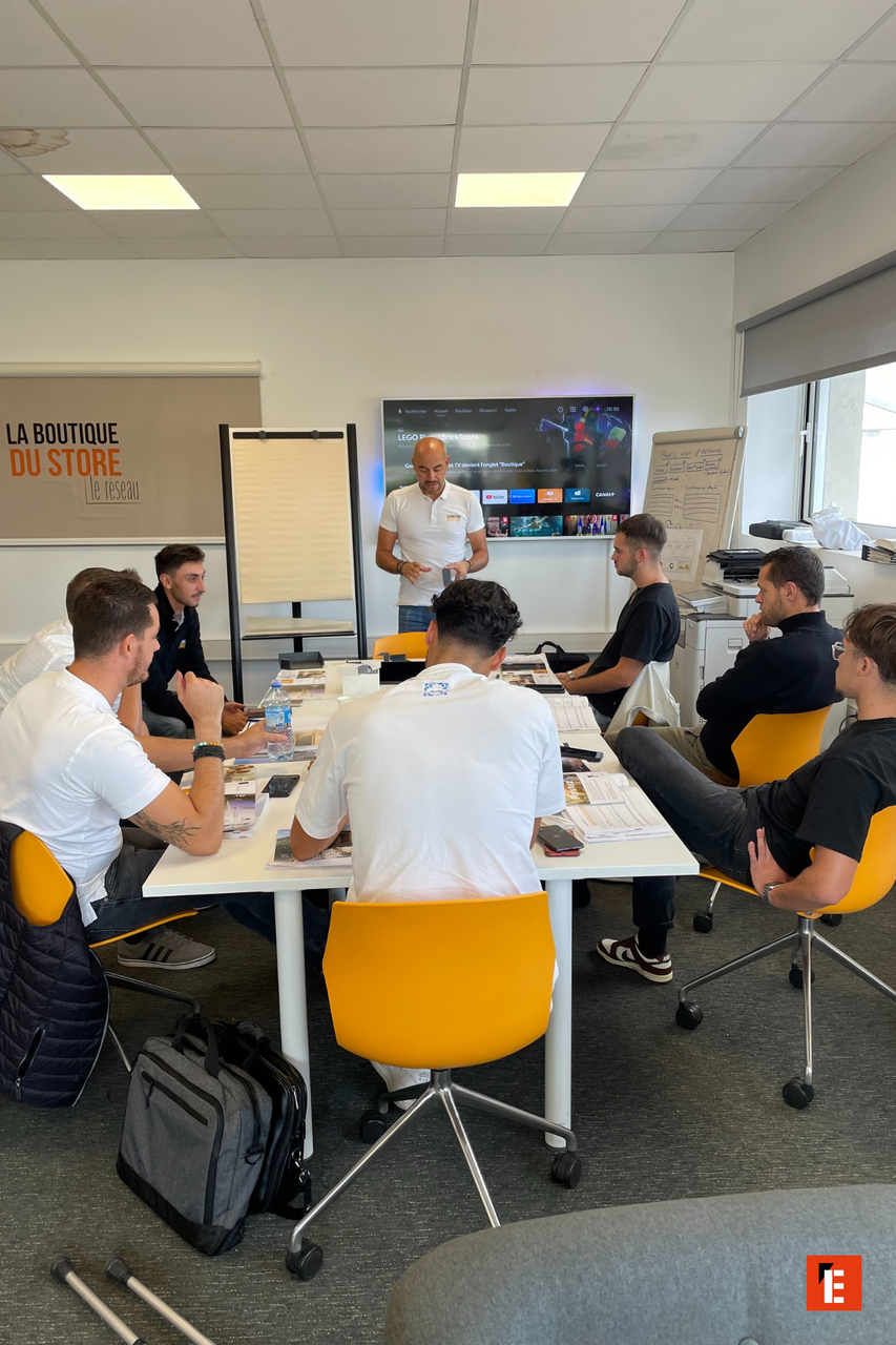 Réunion d'équipe autour d'une table, présentation en cours.