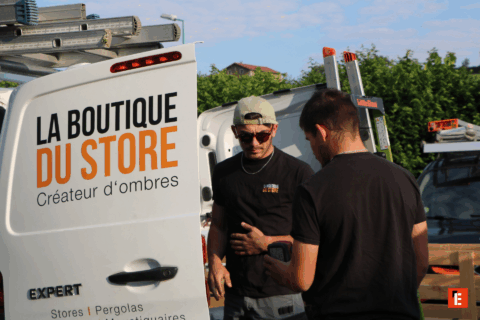 Deux hommes devant un véhicule de la boutique.