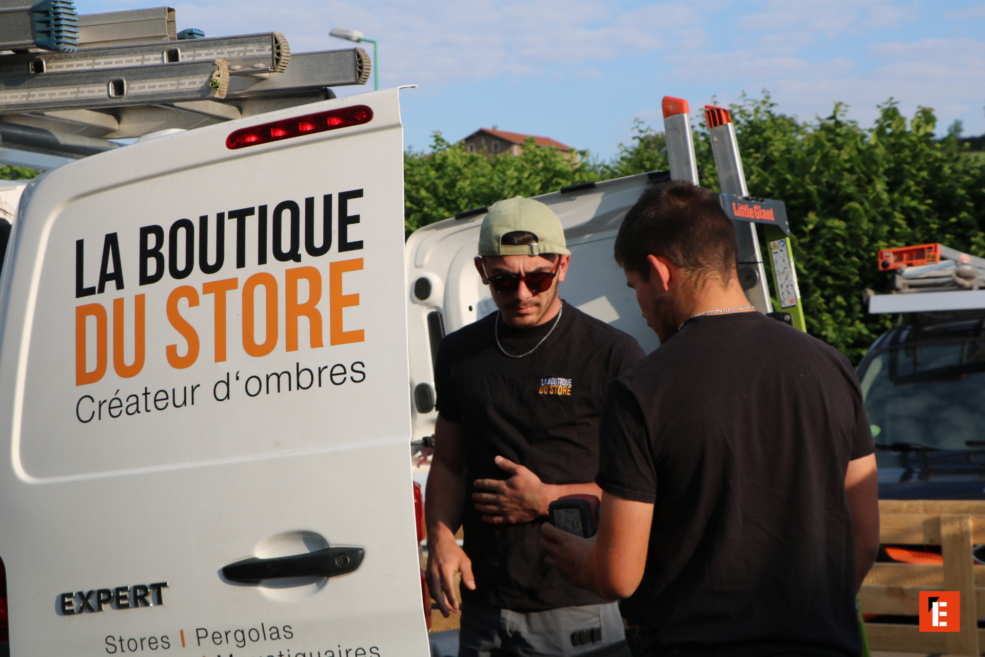 Deux hommes devant un véhicule de la boutique.