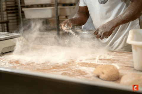 boulanger saupoudrant de la farine