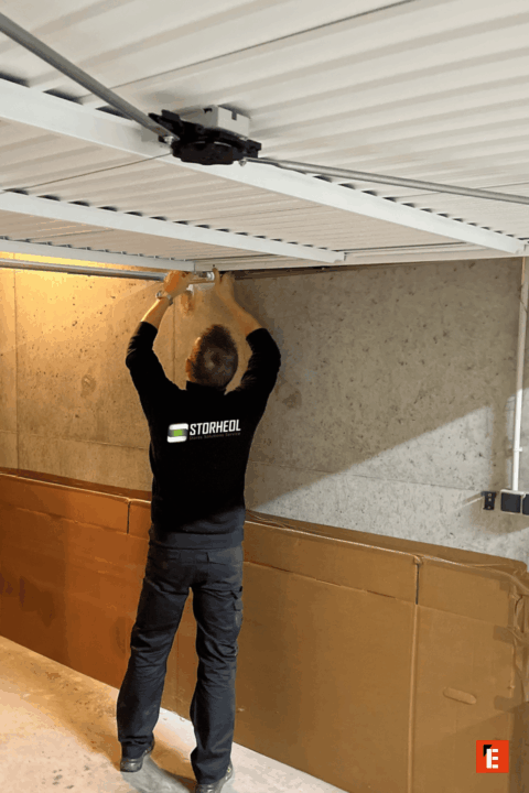 Homme installe un système de garage suspendu.