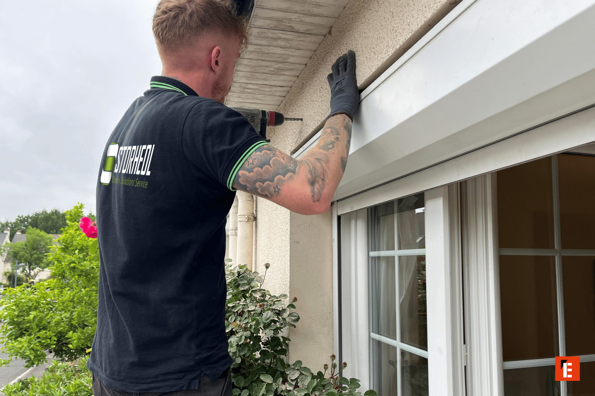 Technicien installant un auvent sur une fenêtre.