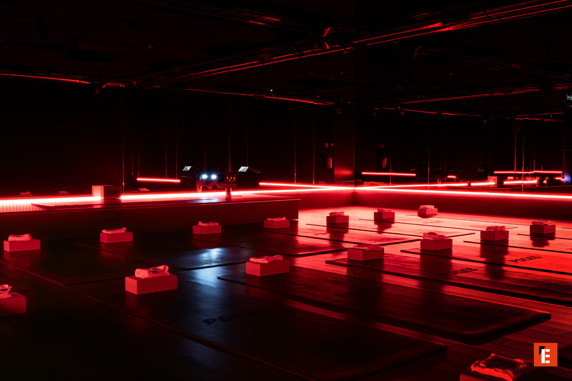 Salle de sport avec éclairage rouge et équipements.