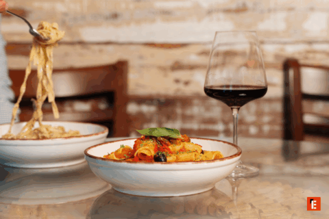 Delicious pasta dish with a glass of red wine.
