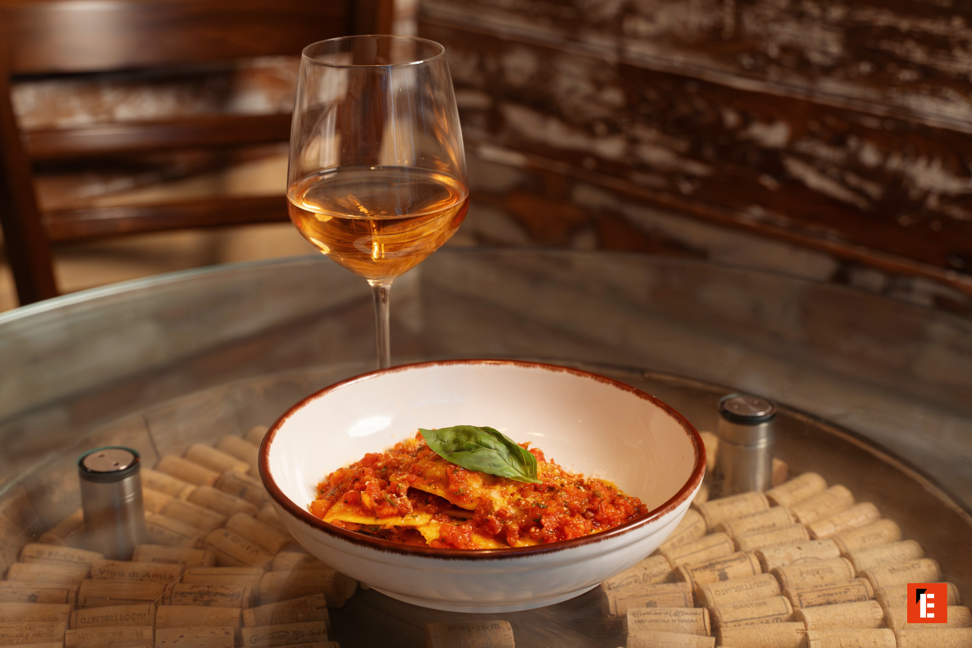 Plate of pasta with sauce and glass of wine.