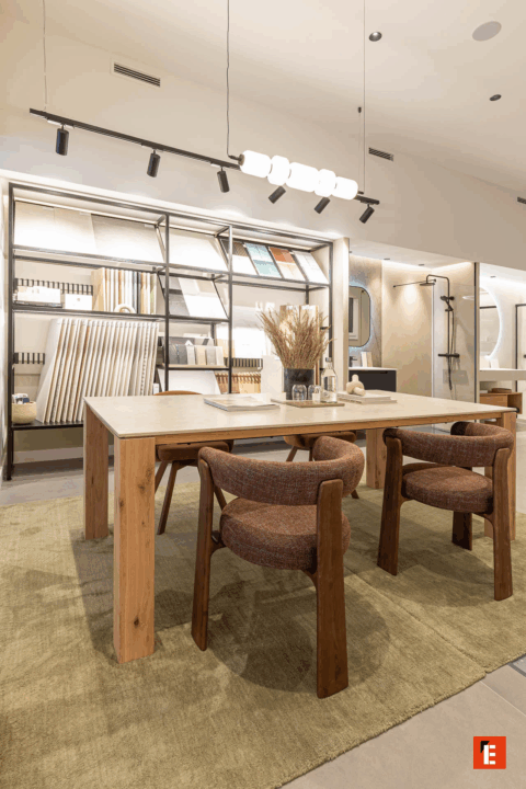 Mesa de trabajo con sillas y estanterías decorativas.