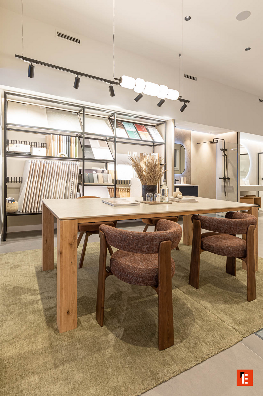 Mesa de trabajo con sillas y estanterías decorativas.