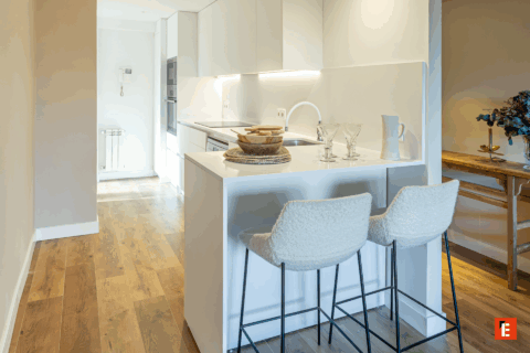 Cocina moderna con isla y barra de desayuno.