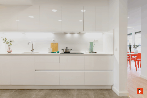 Cocina moderna con muebles blancos y utensilios.