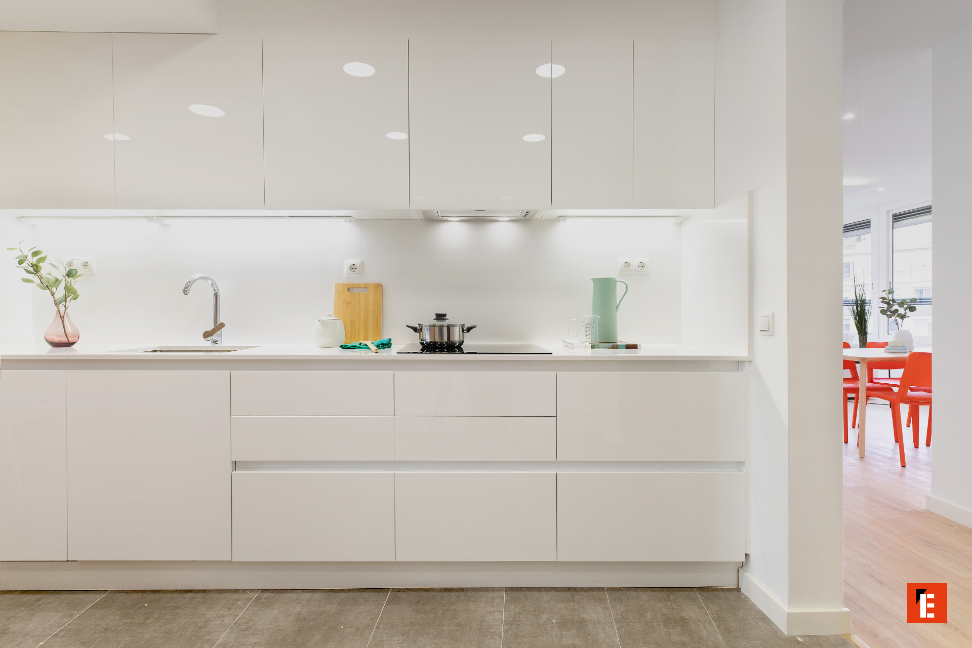 Cocina moderna con muebles blancos y utensilios.