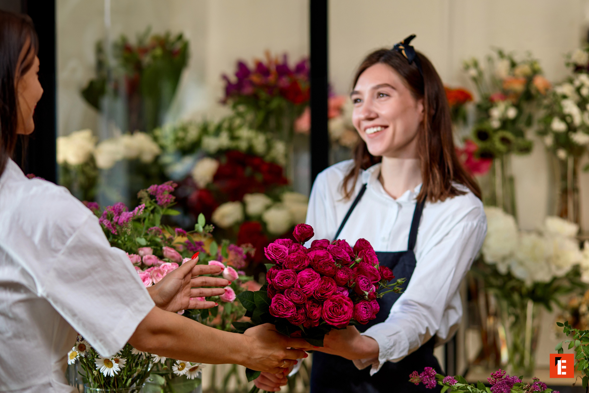 Mujer sonriente entrega ramo de flores.