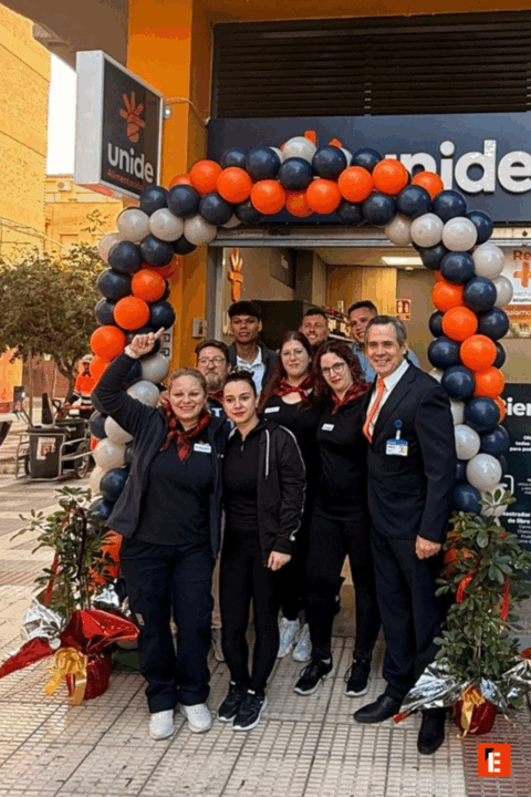 Equipo sonriente frente a la tienda Unide.