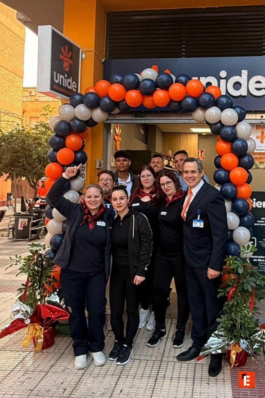 Equipo sonriente frente a la tienda Unide.