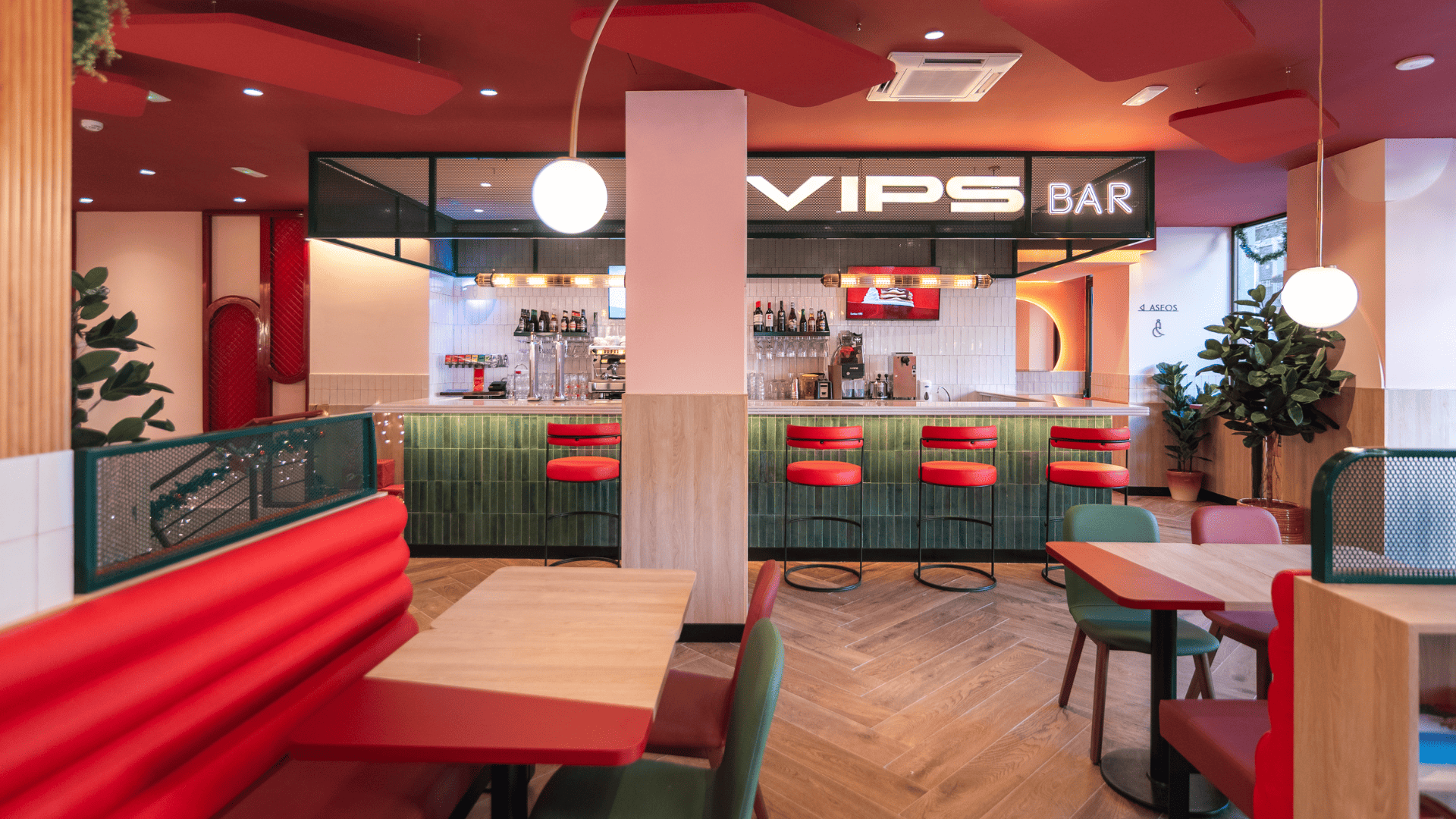 Interior moderno de un bar con asientos coloridos.