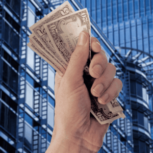 mano con billetes y edificios de oficinas