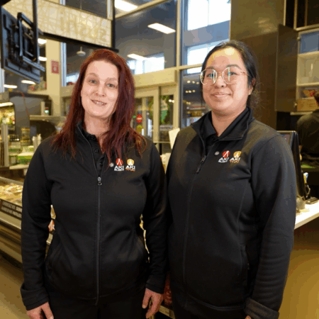 Deux employées souriantes dans un magasin.