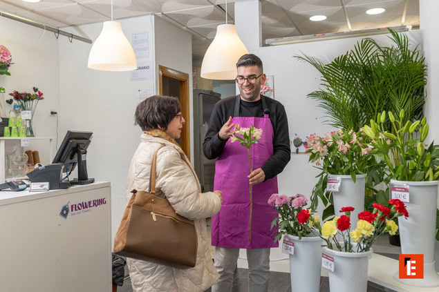 floristería: dependiente atiende a cliente sonriente