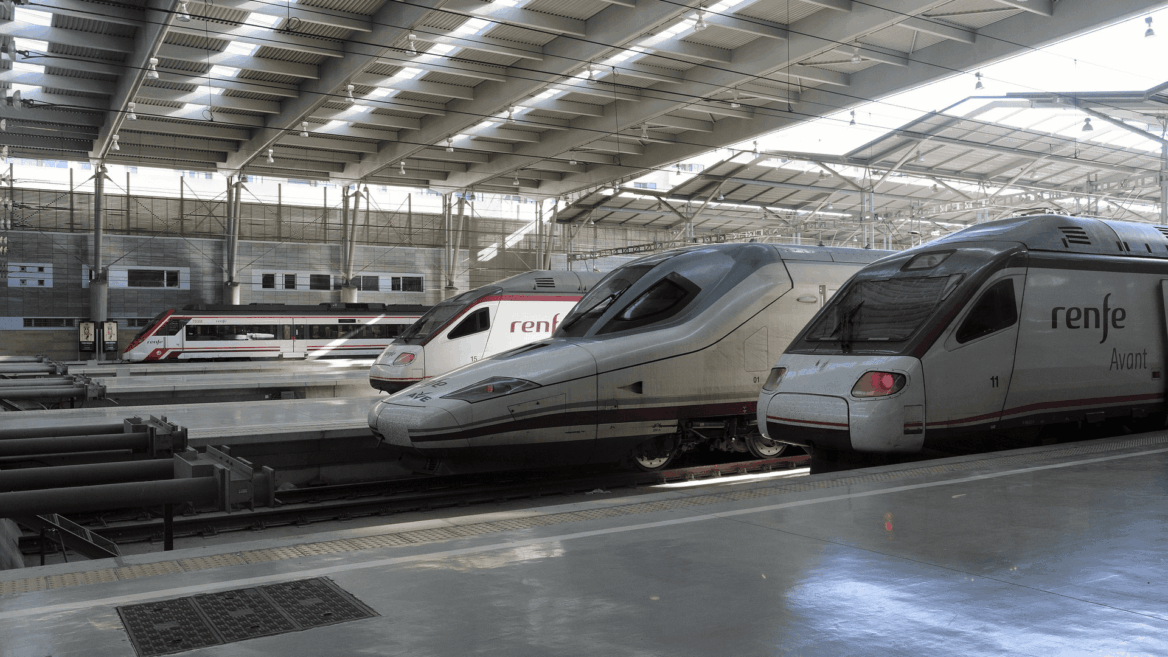 Varios trenes de Renfe en una estación moderna.