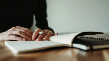 una donna legge e sta per firmare un documento